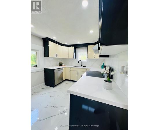 A modern kitchen with black and white cabinets and a marble floor.