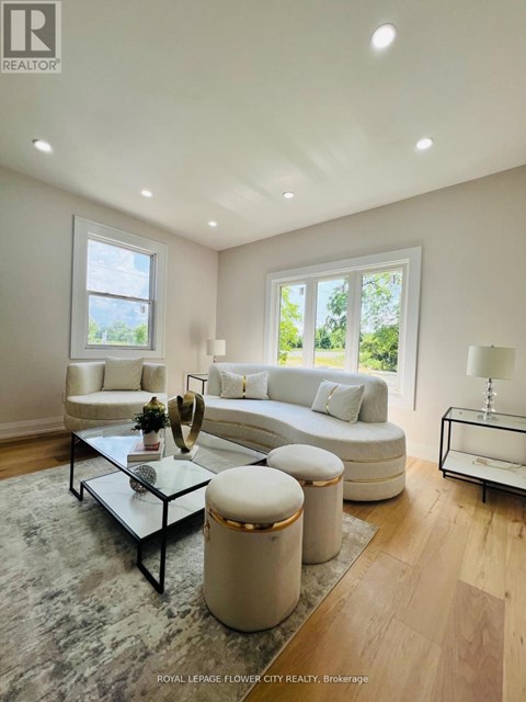 A well-lit, modern living room with a glass coffee table and a white sofa.