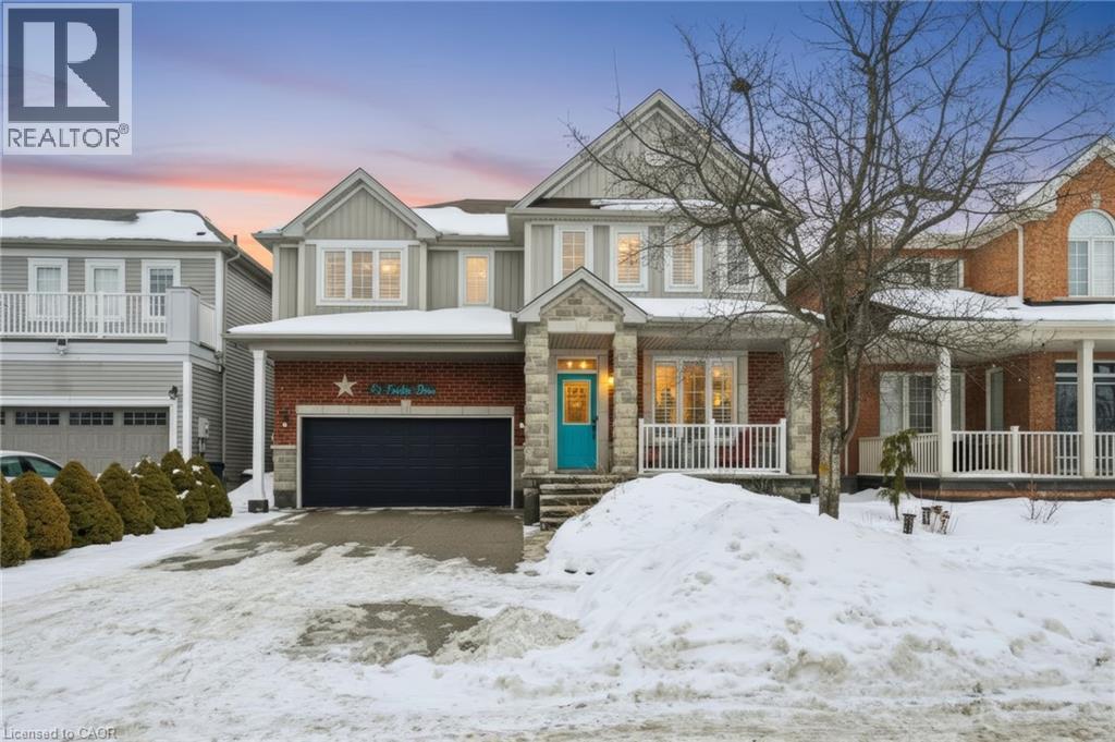 A house with a blue garage door is surrounded by snow.