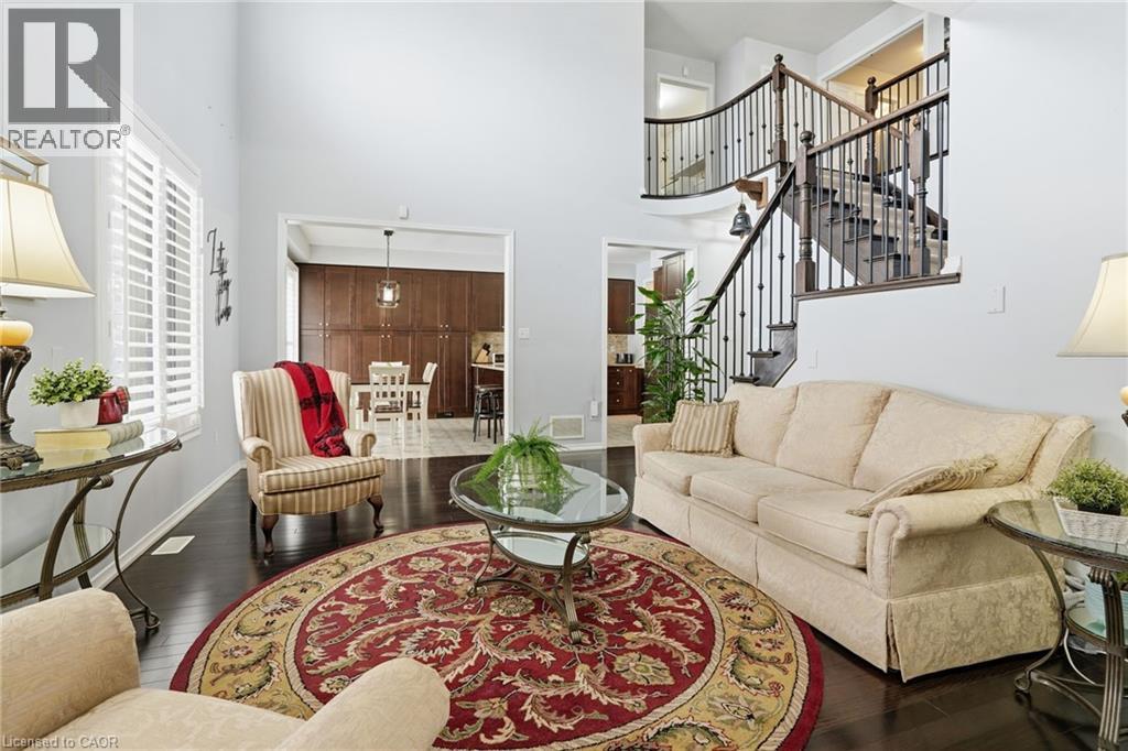 A living room with a rug, a couch, a chair, a table and a staircase.