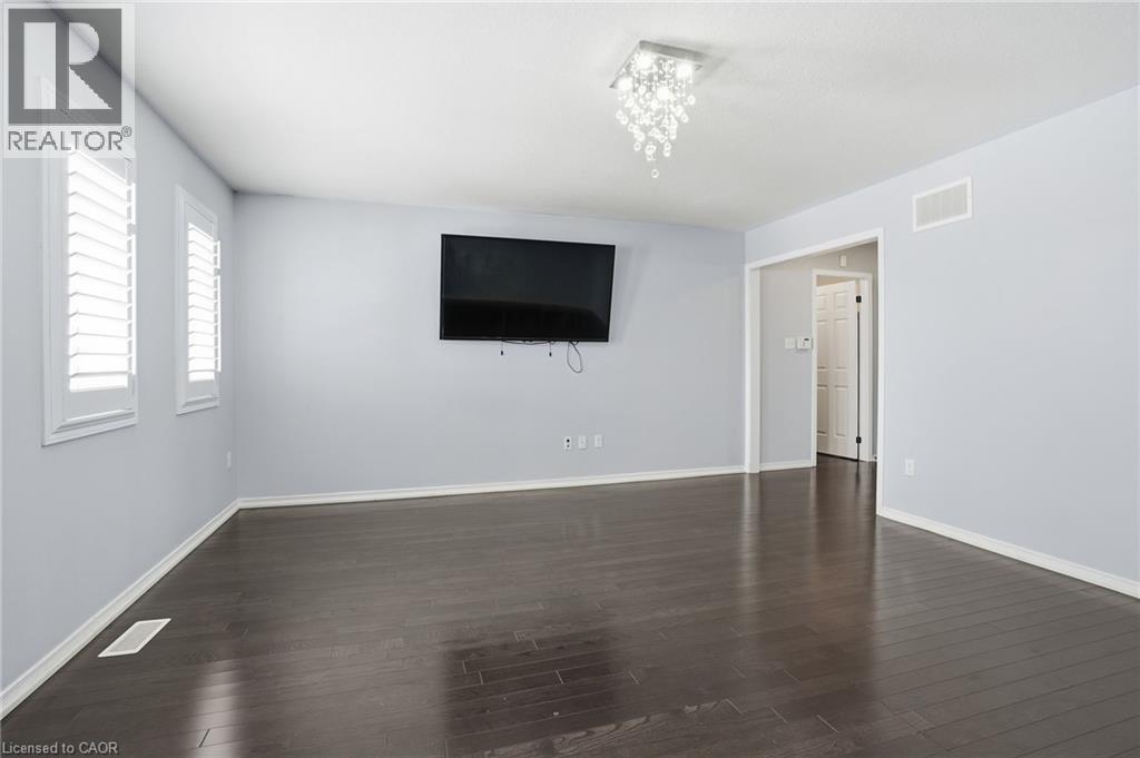 A spacious room with a flat screen TV mounted on the wall.