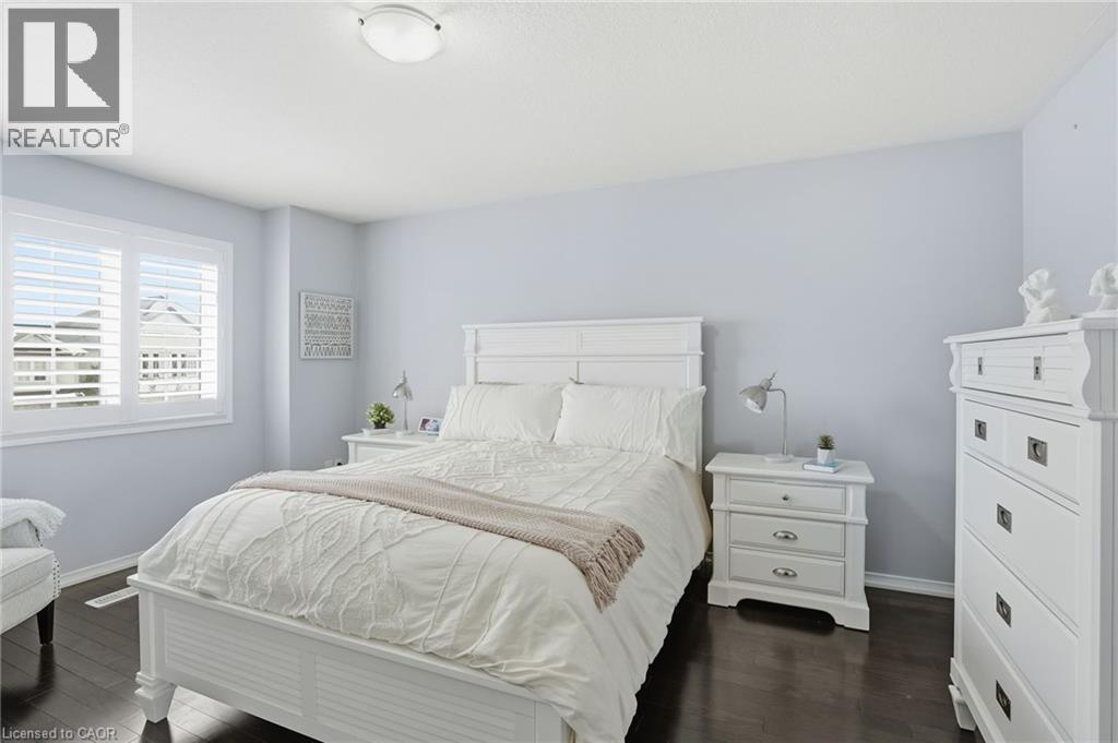 A bedroom with a white bed and a white nightstand.