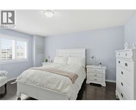 A bedroom with a white bed and a white nightstand.