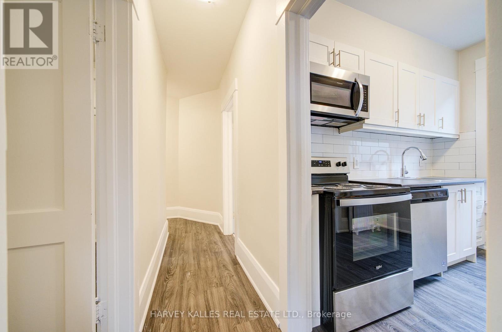 A kitchen with a stainless steel oven and white cabinets.