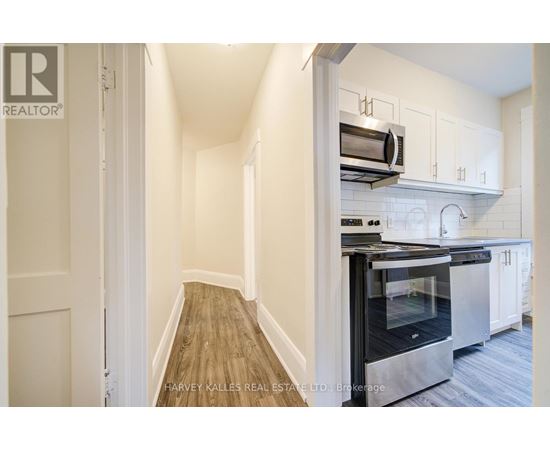 A kitchen with a stainless steel oven and white cabinets.