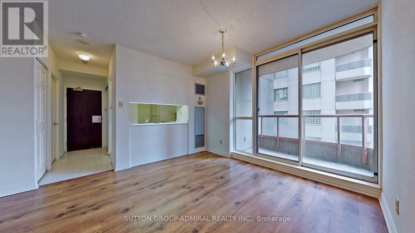 A room with a large window and wooden flooring.