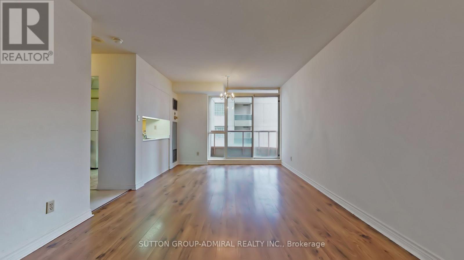 A large empty room with wooden floors and white walls.