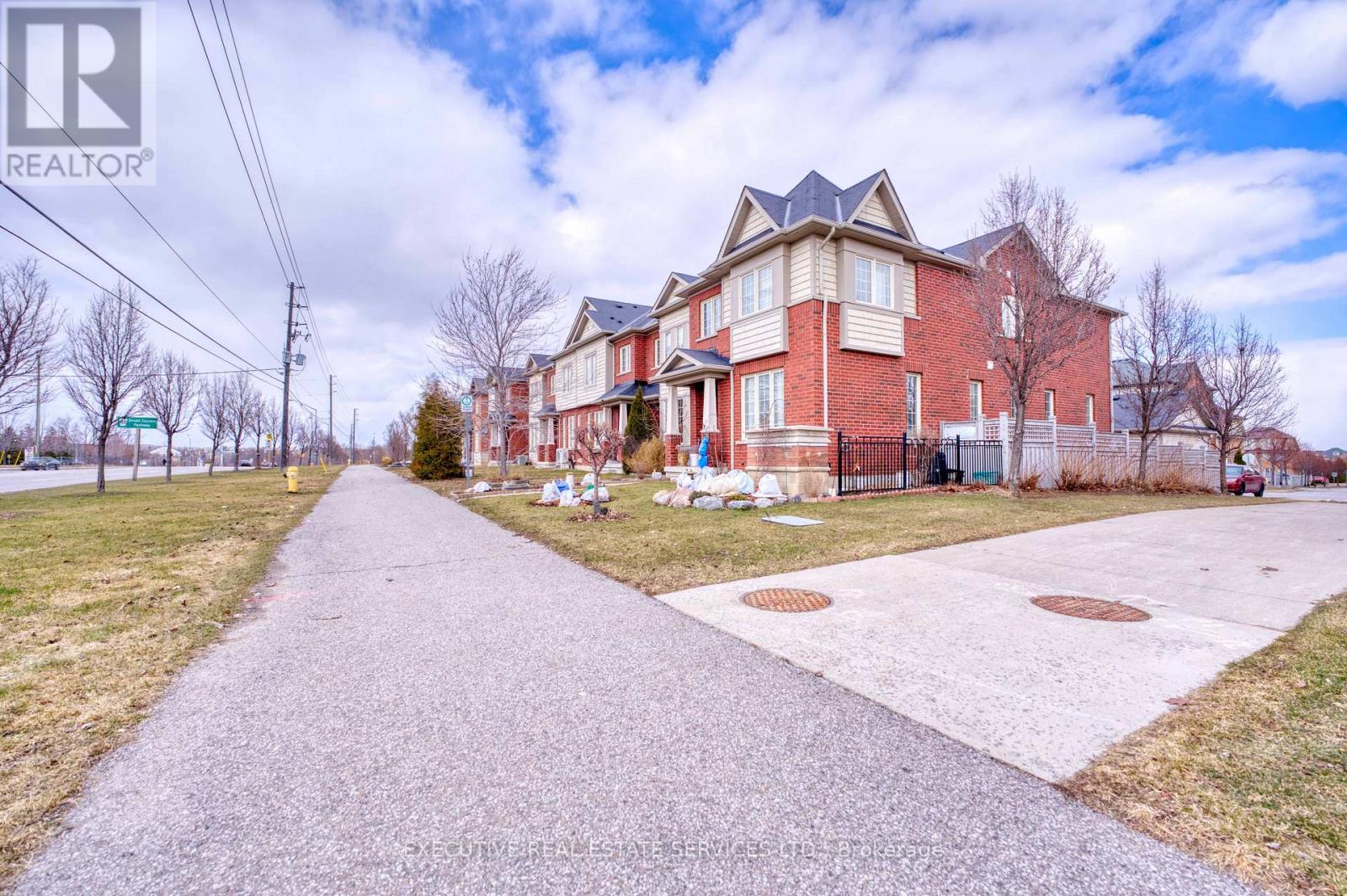 A red brick house with a driveway in front.