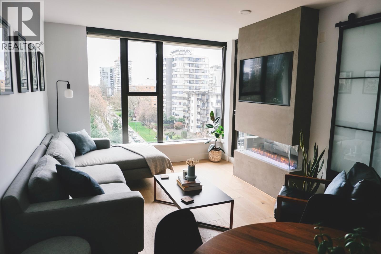 A living room with a couch, a chair, a coffee table, and a television.