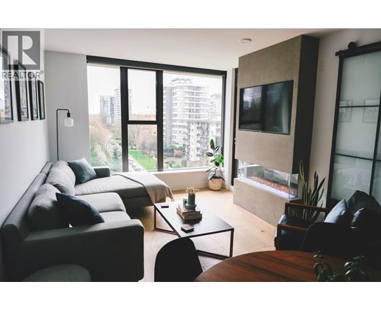 A living room with a couch, a chair, a coffee table, and a television.