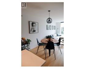 A dining room with a table and chairs.