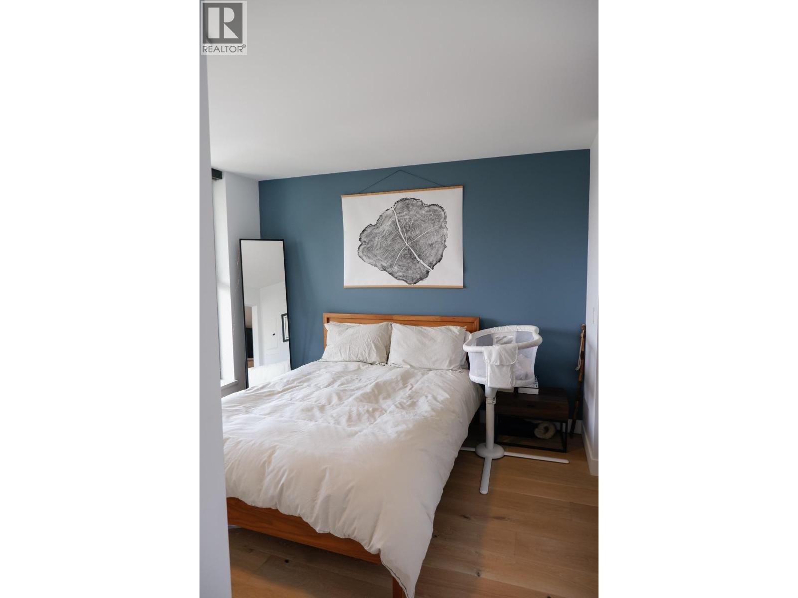 A bedroom with a white bed and a white chair.