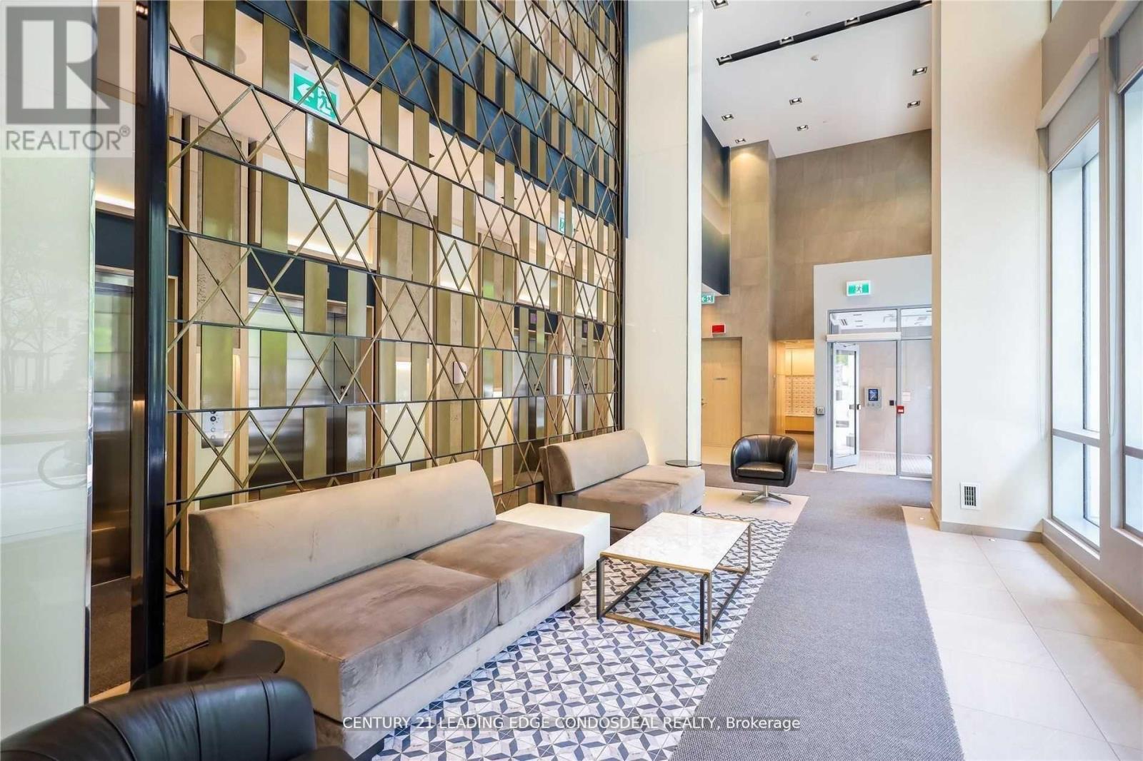 A hallway with a glass wall and a bench.