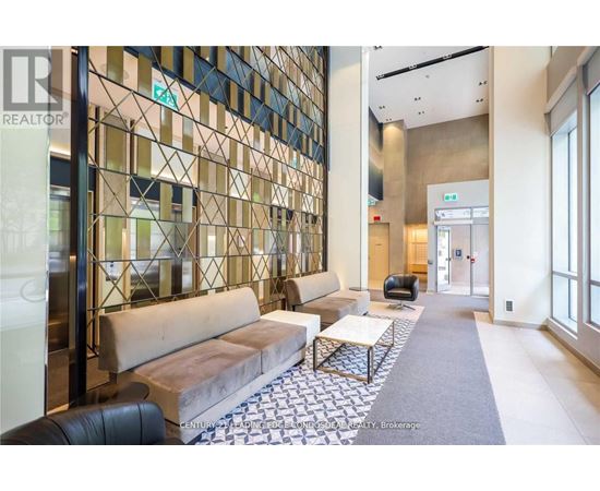 A hallway with a glass wall and a bench.