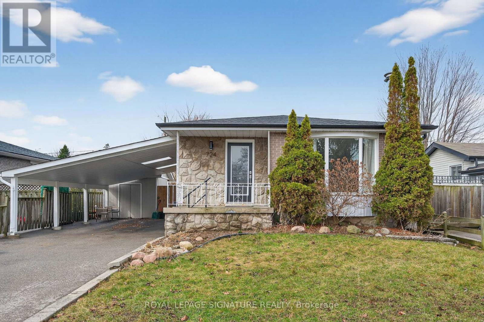A house with a covered patio and a stone wall.