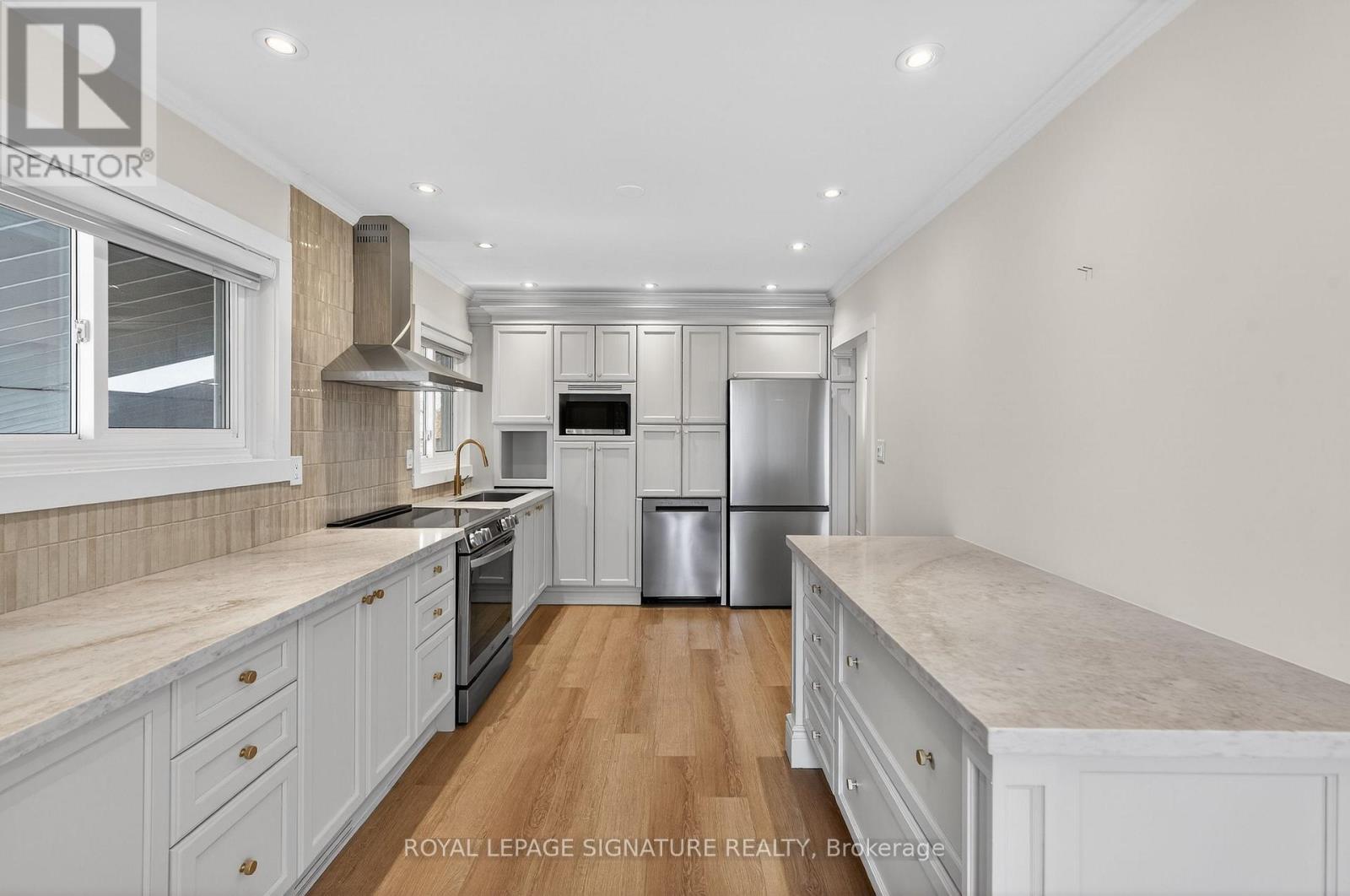 A kitchen with a refrigerator, stove, and oven.