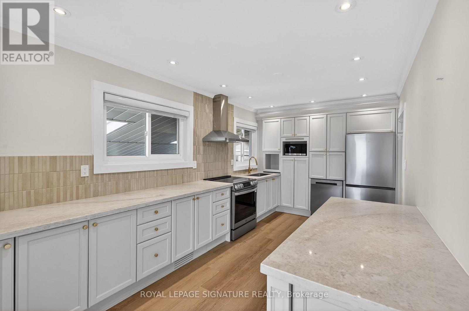 A kitchen with white cabinets and a marble countertop.