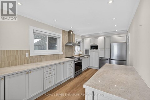A kitchen with white cabinets and a marble countertop.
