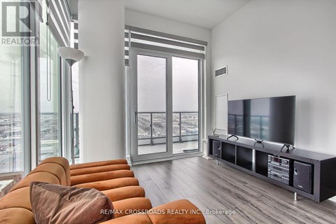 A modern living room with a large orange sofa and a flat screen TV.