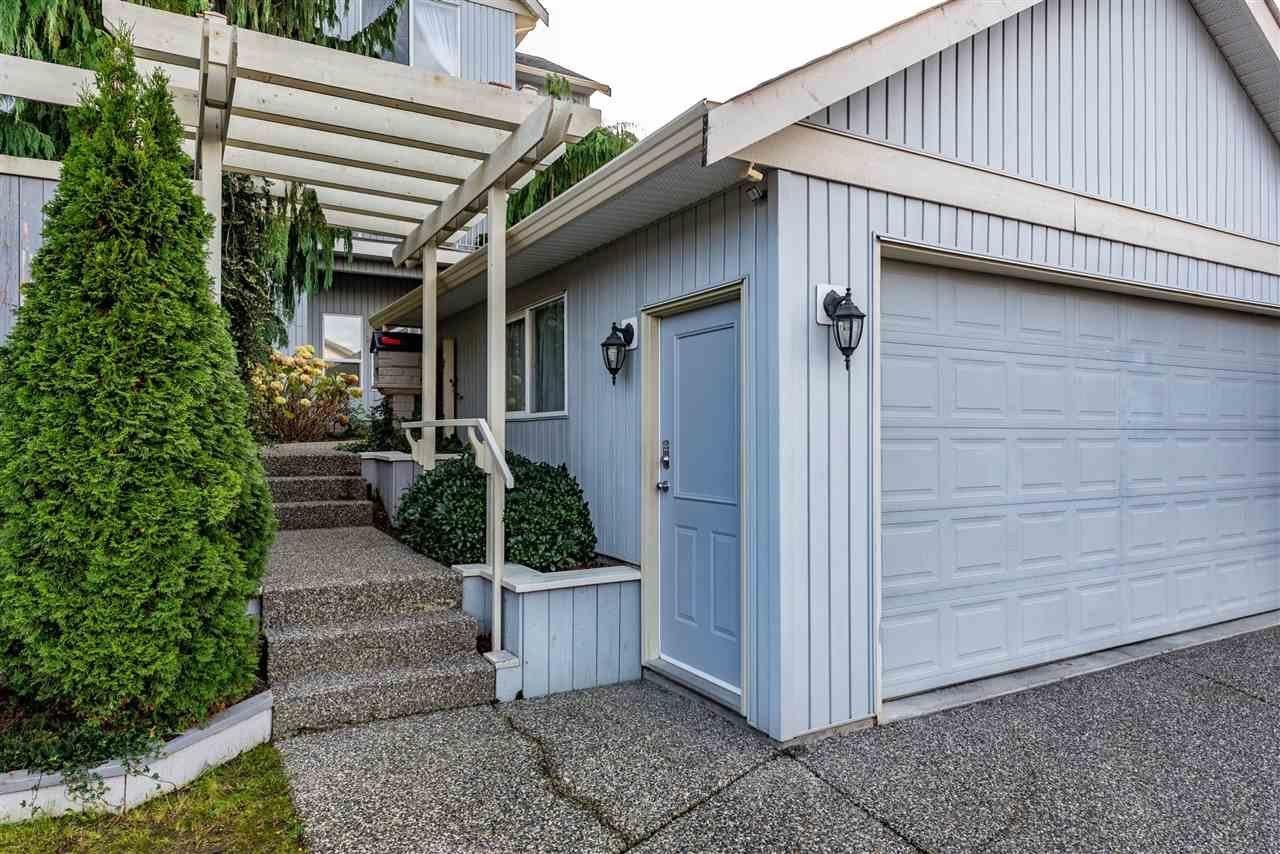 A house with a blue door and a white garage door.