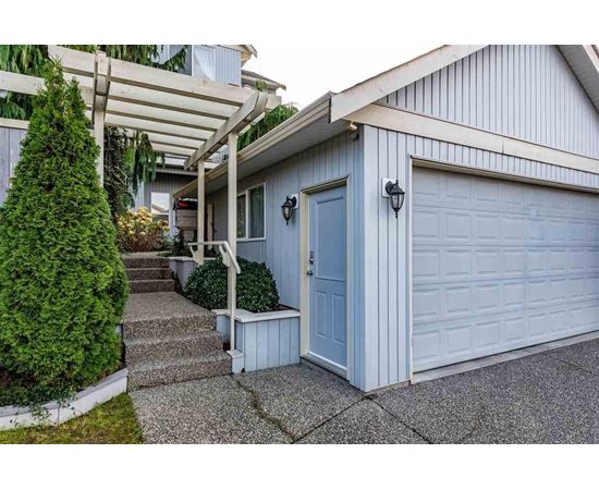A house with a blue door and a white garage door.