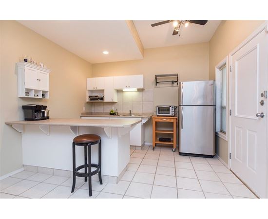 A kitchen with white cabinets and a stainless steel refrigerator.