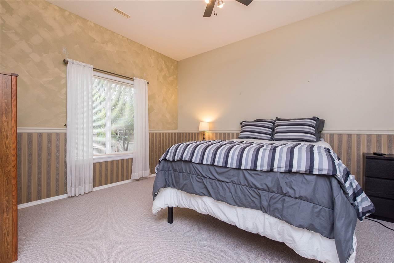 A bedroom with a bed, nightstand, and window.