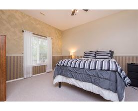 A bedroom with a bed, nightstand, and window.