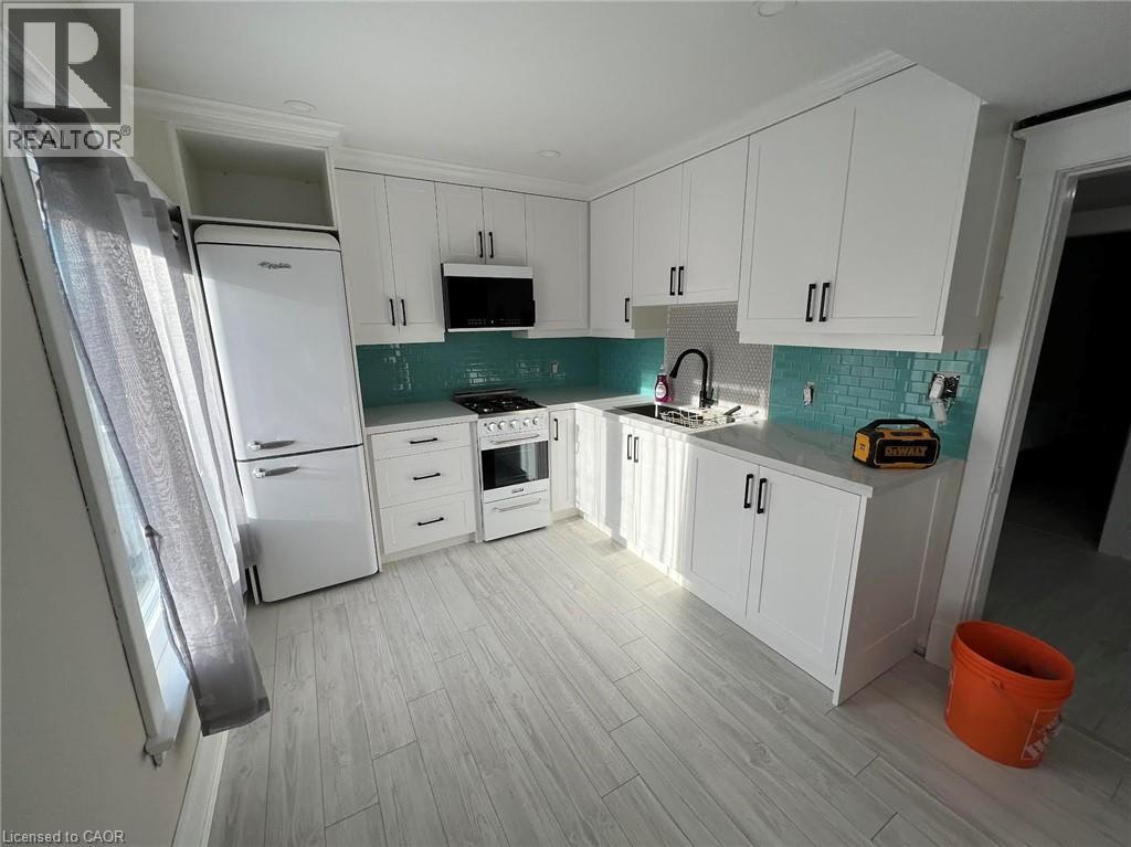 A kitchen with white cabinets and a white fridge.