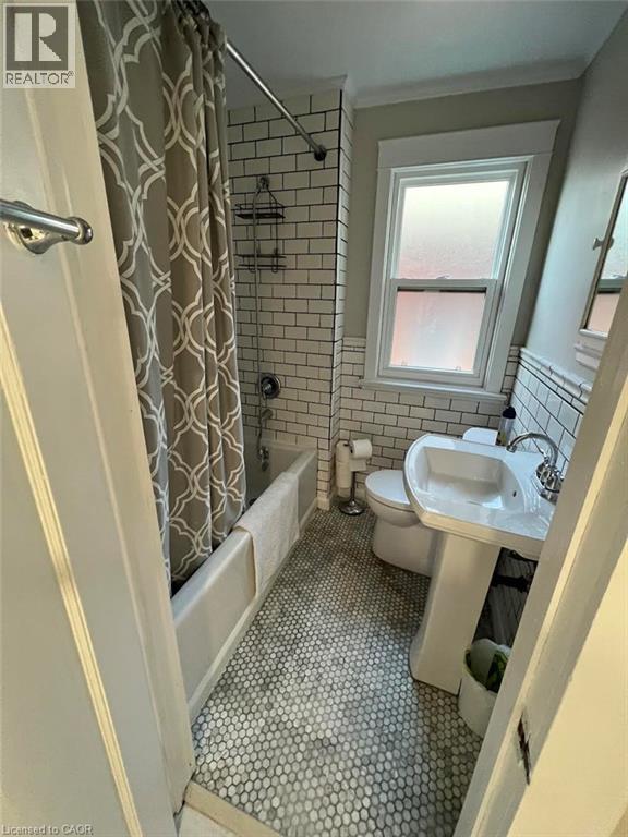 A bathroom with a shower, toilet, and sink.