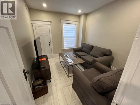 A living room with a brown couch and a flat screen TV.