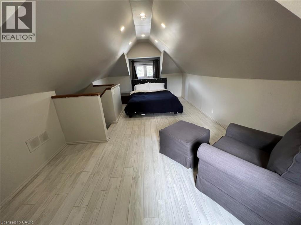 A bedroom with a bed, nightstand, and window.