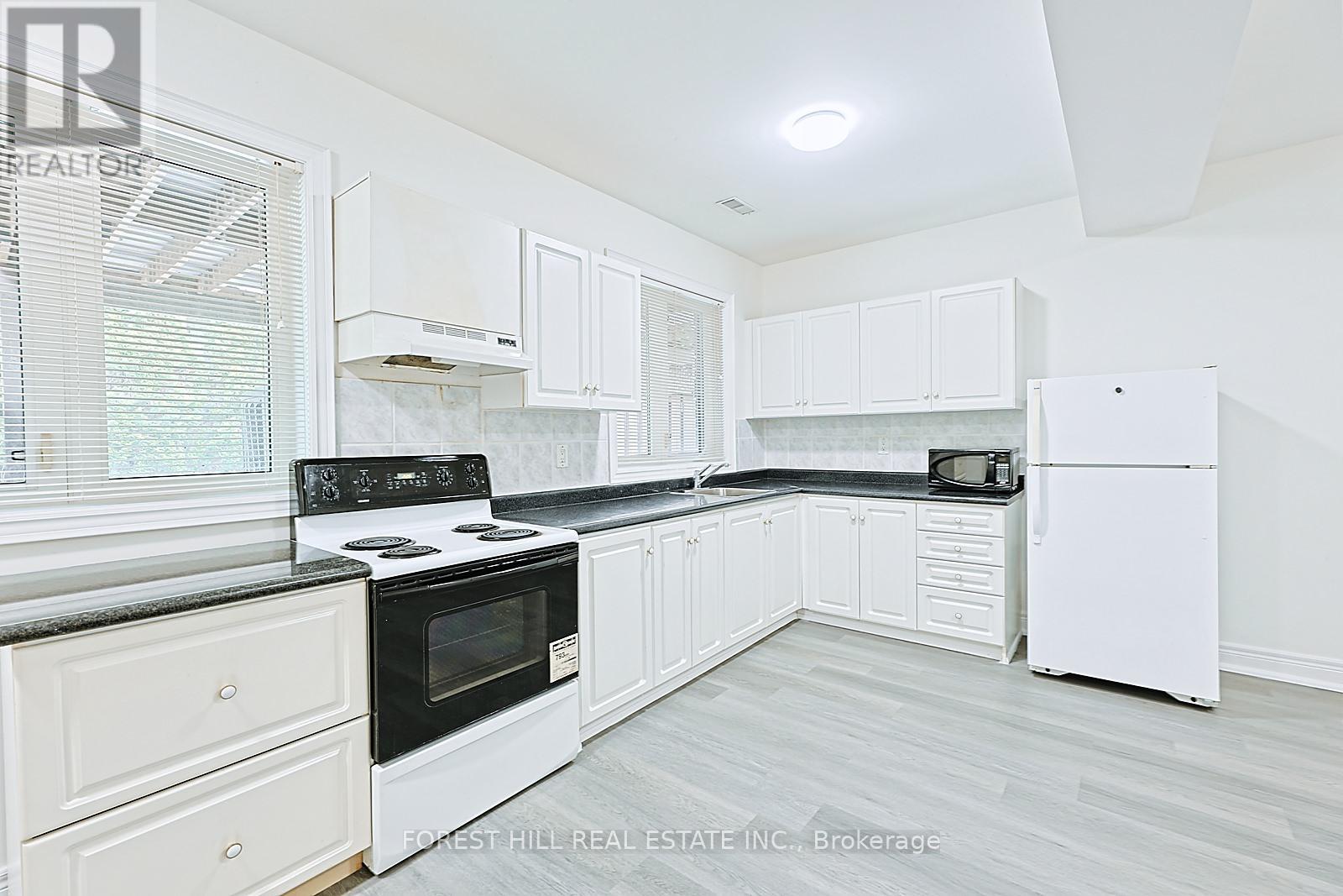 A kitchen with white appliances and cabinets.