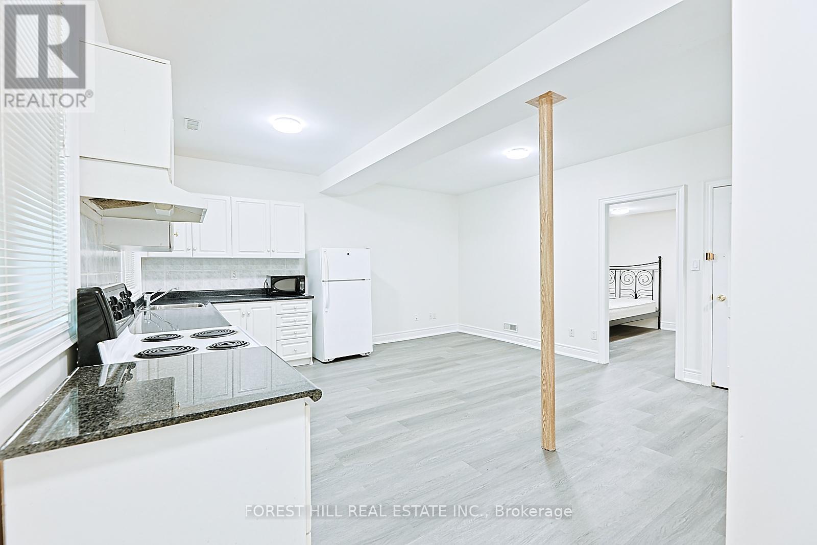 A kitchen with white cabinets and a black countertop.