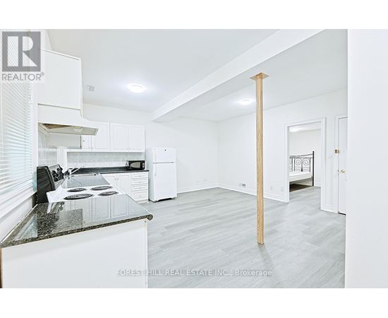 A kitchen with white cabinets and a black countertop.