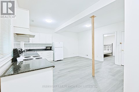 A kitchen with white cabinets and a black countertop.