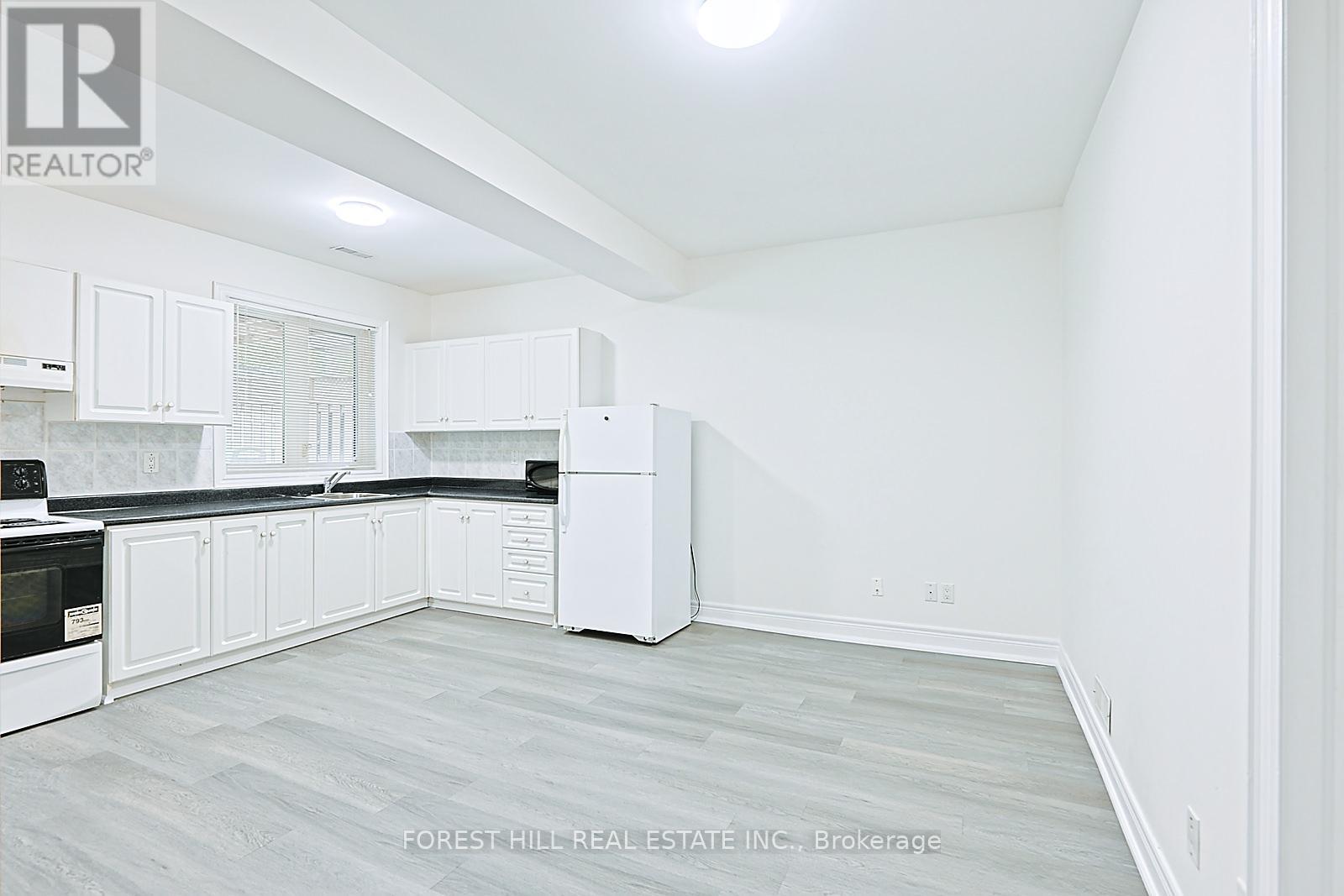A white kitchen with Forest Hill Real Estate Inc. Brokerage watermark.