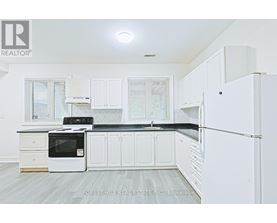 A kitchen with white cabinets and a black countertop.