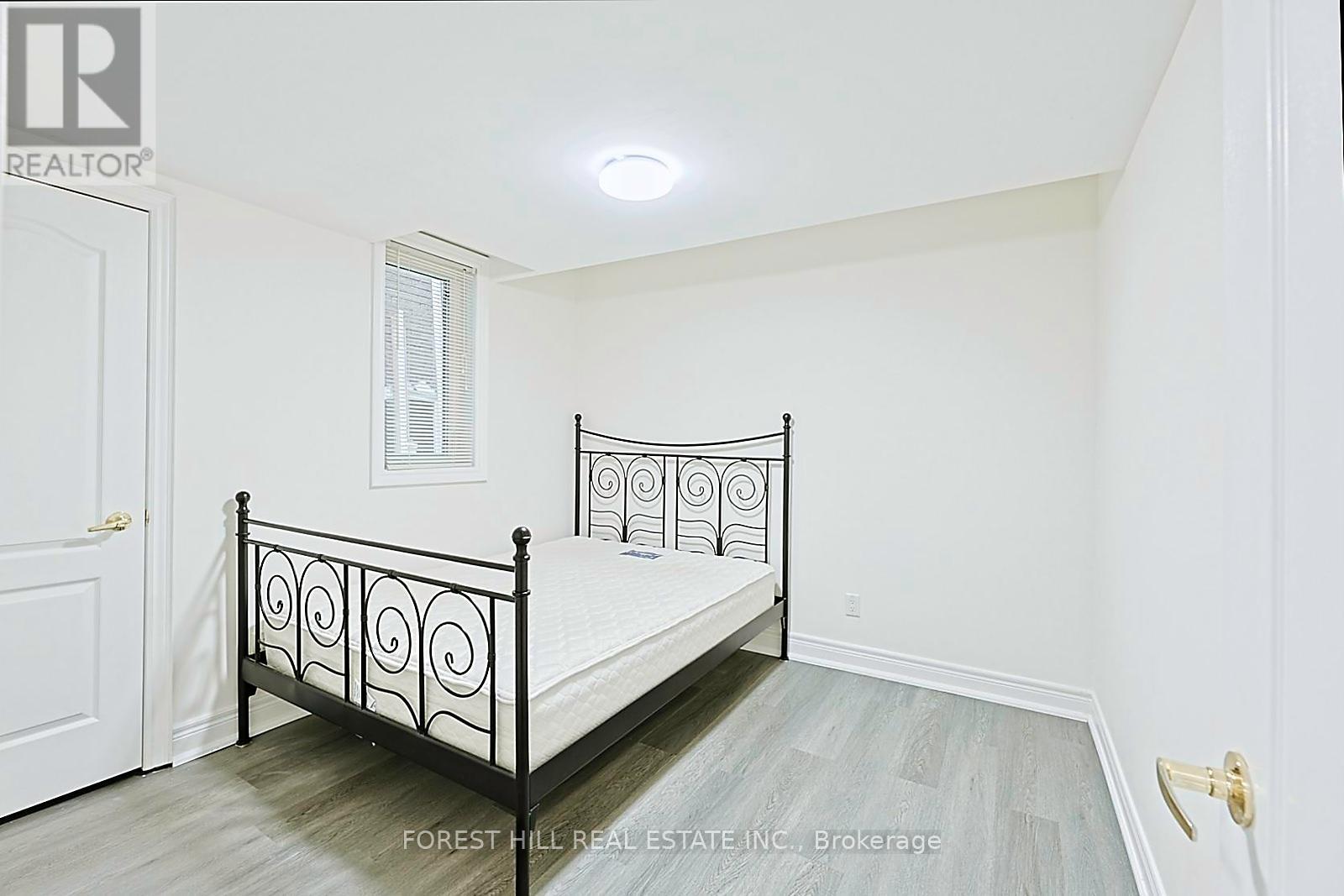 A bedroom with a black metal bed frame and a white door.