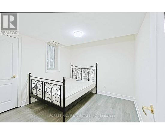 A bedroom with a black metal bed frame and a white door.