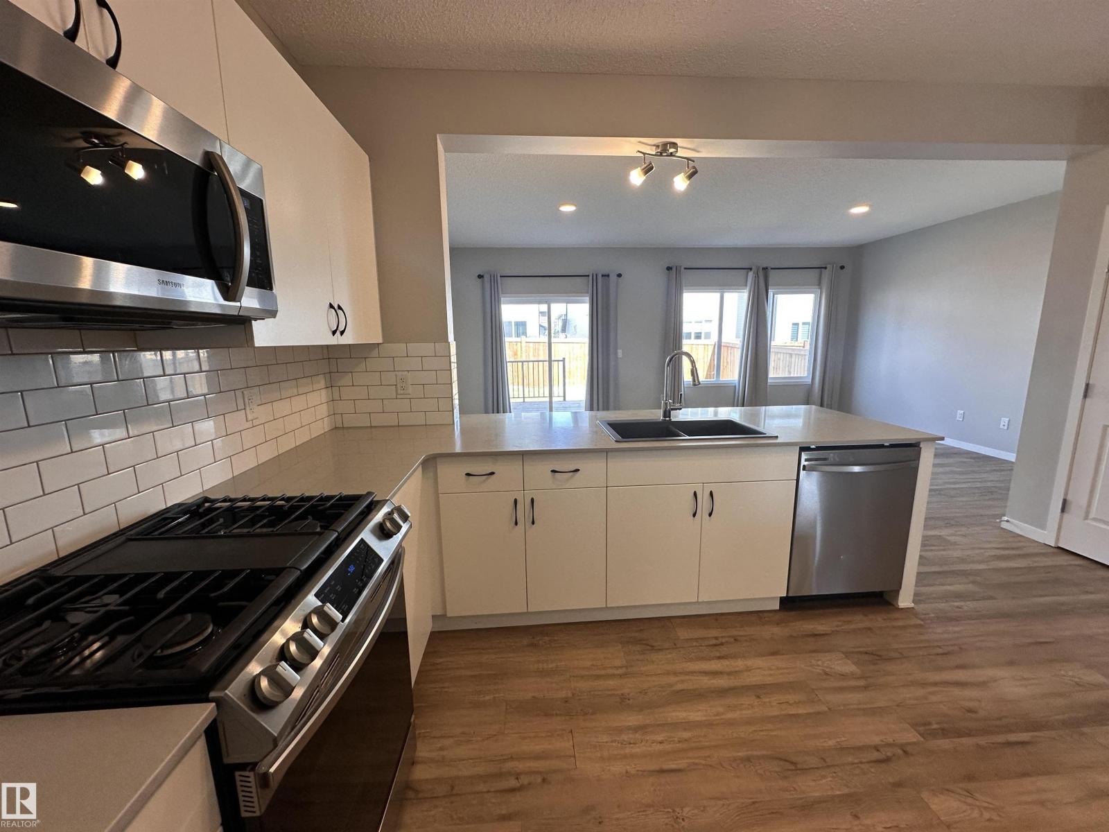 A kitchen with a stove, microwave, and oven.