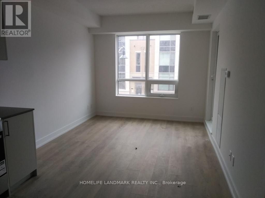 A room with a window and a wooden floor.