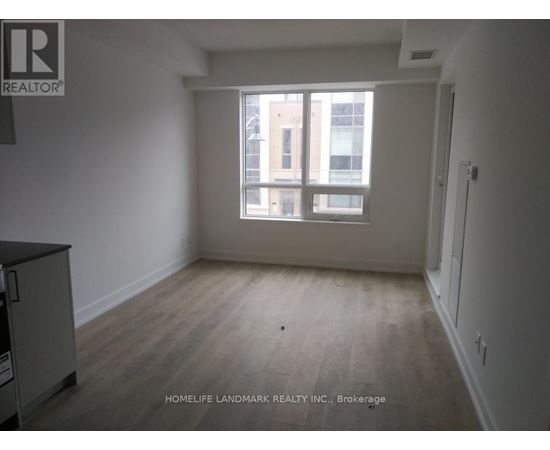 A room with a window and a wooden floor.