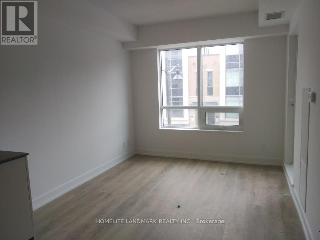 A room with a large window and wooden flooring.