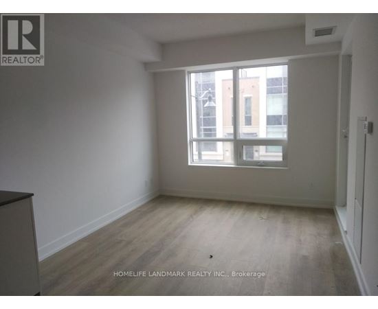 A room with a large window and wooden flooring.