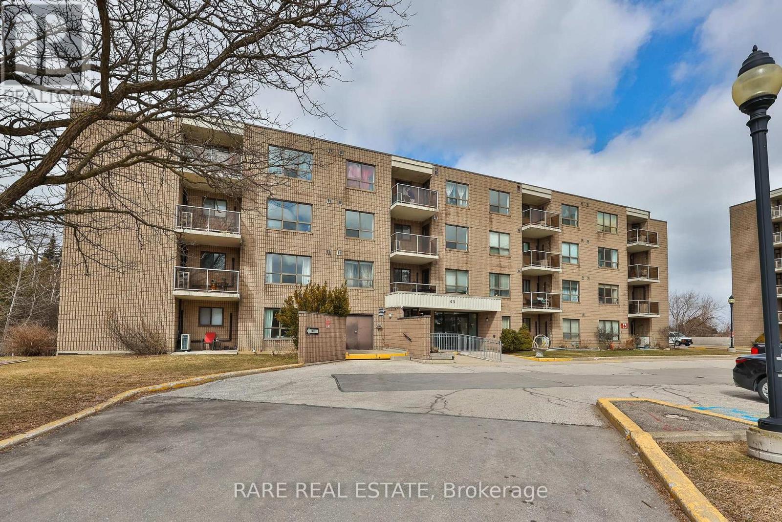 A large apartment complex with a parking lot in front.