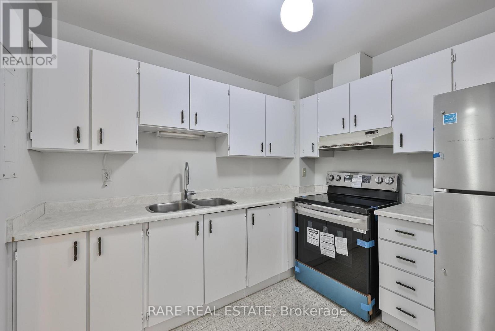 A kitchen with white cabinets and a sink.