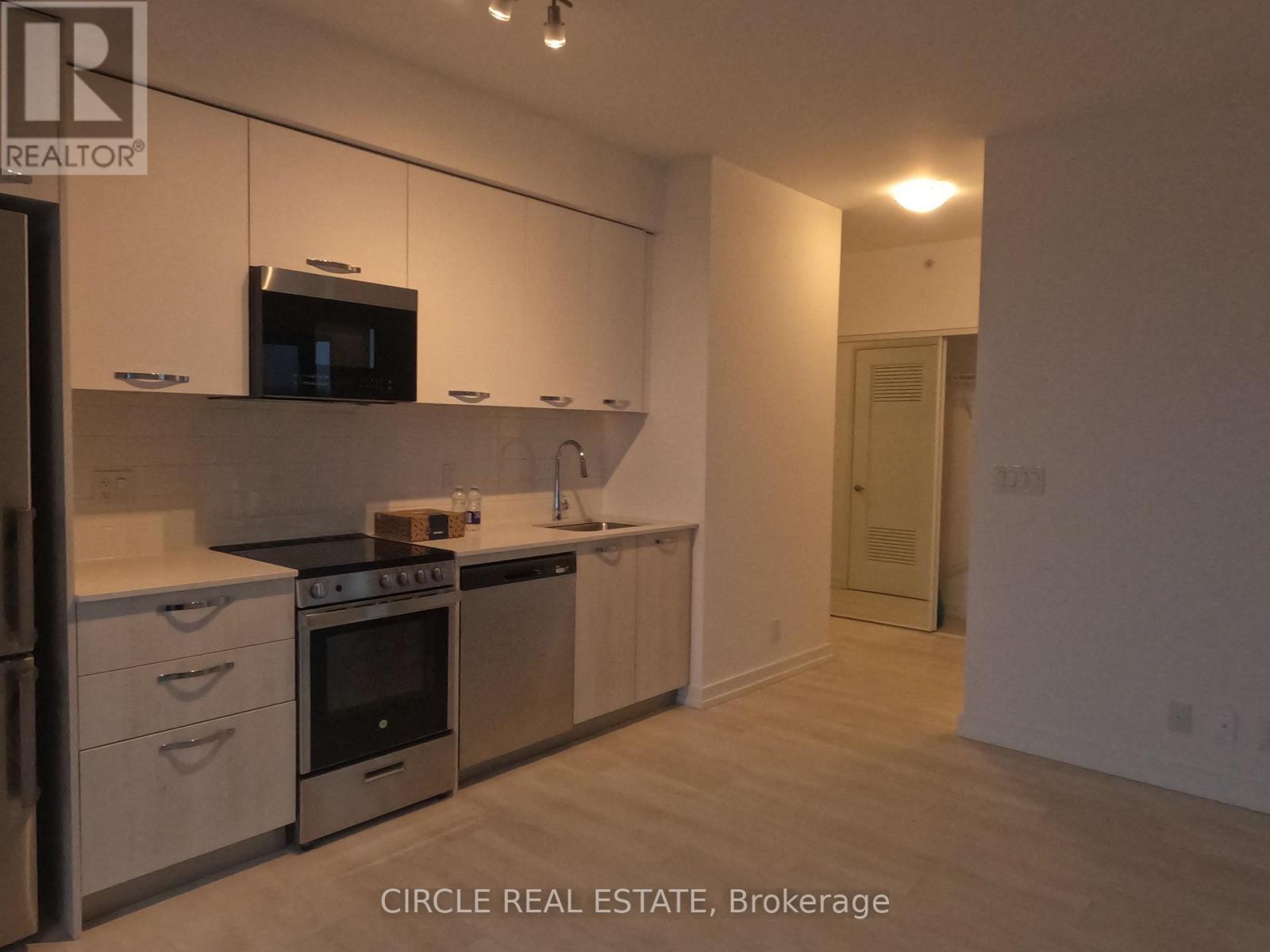 A kitchen with white cabinets and a microwave above the stove.