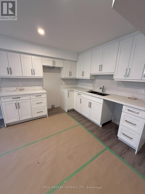 A kitchen with white cabinets and a countertop is under construction.