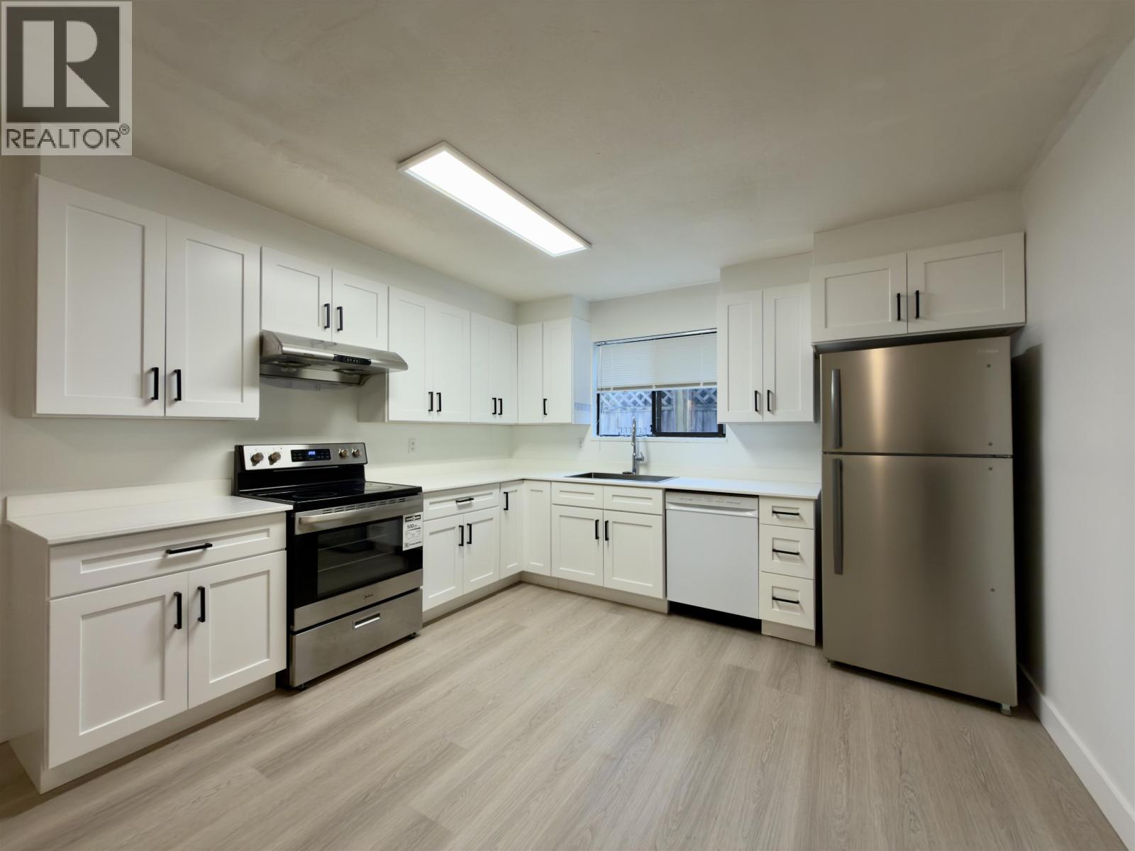 A kitchen with white cabinets and stainless steel appliances.